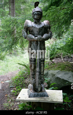 Suit of armour, knight, standing at foot of rough rural driveway Stock Photo