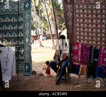 clothes stall and stallholder at Anjuna hippy market, Goa, India, Stock Photo