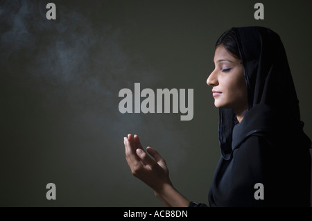 Side profile of a young woman praying Stock Photo