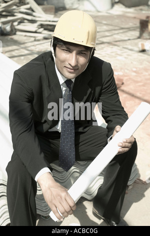 Portrait of an architect holding a blueprint at a construction site Stock Photo
