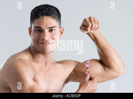 Image of muscular man measure his biceps with measuring tape in  centimeters. Isolated on white backgound Stock Photo by ©Chetty 96260608