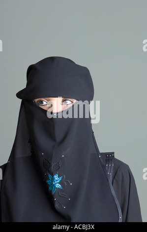Close up head shot of a Muslim woman in a black hijab with eyes looking ...