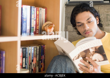 Close-up of a young man reading a book in a library Stock Photo