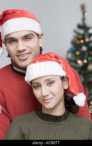 Portrait of a young couple wearing Santa hats Stock Photo