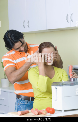 Young man covering a young woman's eyes with his hands Stock Photo