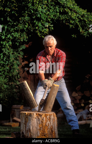 Retired man chopping wood Stock Photo