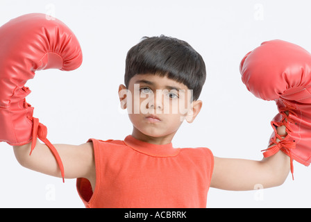 Portrait of a boy wearing boxing gloves and flexing his muscles Stock Photo
