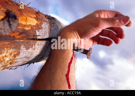 Detail from Crucifixion: a hand nailed through the wrist to a horizontal wooden beam. Most revered symbol of Christianity. Stock Photo