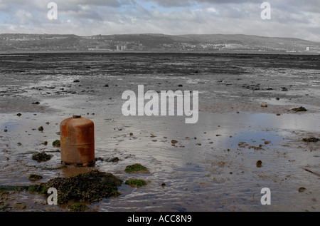 The River Clyde estuary shoreline with old gas canister embedded in mud at Cardross, Scotland, looking south to Port Glasgow Stock Photo