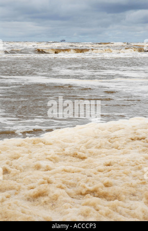Foam used to tackle an oil spillage on the beach at Formby near Southport Stock Photo