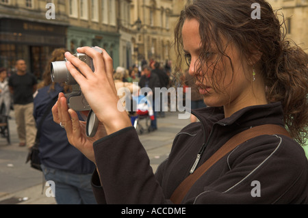 Young woman long hair taking a photograph with Canon digital camera Stock Photo