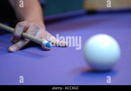 a pool player about to cue the white ball on a pool table Stock Photo
