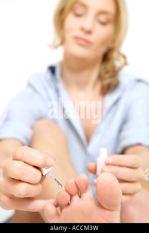 Woman putting on nail polish. Stock Photo