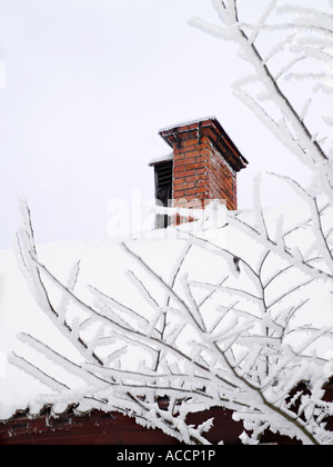 A chimney on a roof covered in snow. Stock Photo