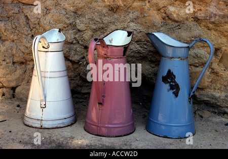 old enamel jugs in colours of white red and blue at a masonry Stock Photo