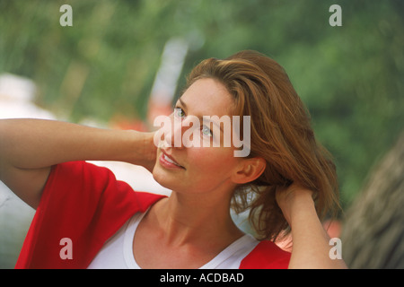 Woman with auburn hair and red sweater in happy mood Stock Photo