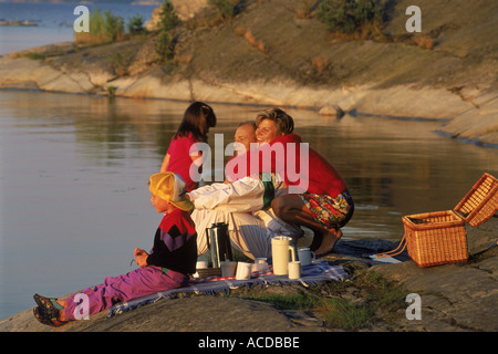 Family of four having picnic on rocky shore in Stockholm Archipelago Stock Photo