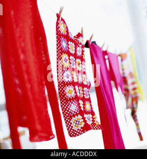 Colourful clothes hanging out on a clothes line to dry. Stock Photo