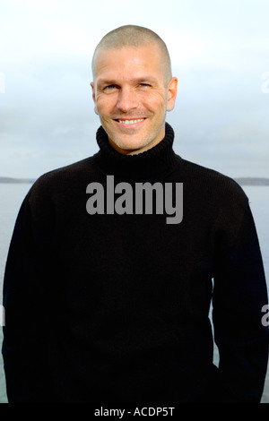 A smiling man looking at the camera dressed in a black sweater portrait. Stock Photo