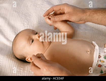 Baby boy holding his fathers hands, U.K. UK Stock Photo