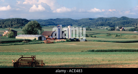 Wisconsin dairy farmland showing barns silos fields and farm machines spread out on a wide field canvas Stock Photo