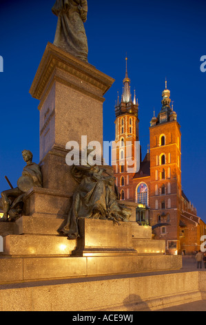 statue in the Main Market Square Rynek Glowny with the Church of St Mary at night Krakow Cracow Poland NR Stock Photo