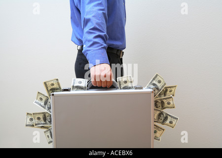 Man holding briefcase stuffed full of money Stock Photo