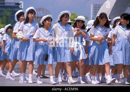 A group of school girls in blue and white sailor uniforms visiting Hiroshima during a school trip Stock Photo