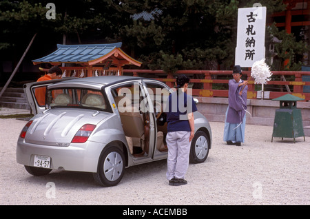 Young couple having their new Toyota Will motor car blessed by Shinto priest at Heian Jingu shrine to rid it of evil spirits Stock Photo