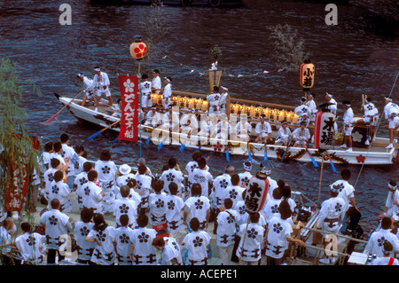 Teams of men wearing yukata robes boarding a boat during the summer Tenjin Festival of Osaka Stock Photo
