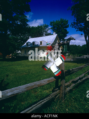 whirl-a-gig mounted on fence post at a quebec farm house in canada Stock Photo