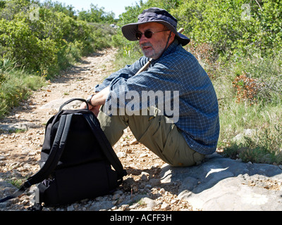 MR middle aged man making tracking hiking in the nature having a pause break on hiking way Stock Photo