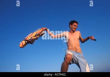 Tall, thin young German man balancing on a post listening to music on his  ipod Stock Photo - Alamy