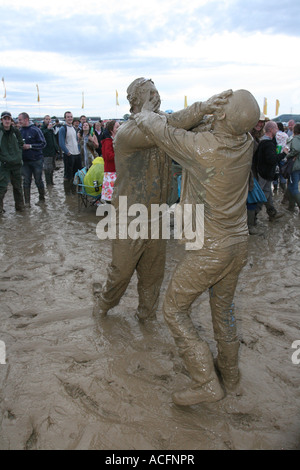 Mud monsters, Two excited young men wrestling in the Mud at the Glastonbury Festival 2007. Stock Photo