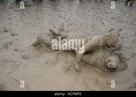 Mud monsters, Two excited young men wrestling in the Mud at the Glastonbury Festival 2007. Stock Photo