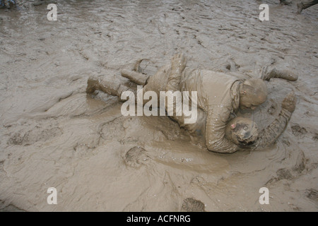 Mud monsters, Two excited young men wrestling in the Mud at the Glastonbury Festival 2007. Stock Photo