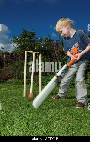 Young child playing cricket in garden Stock Photo