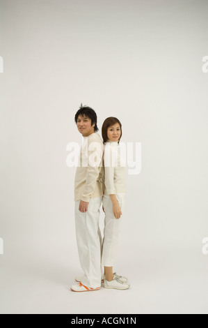 Young couple standing back to back Stock Photo