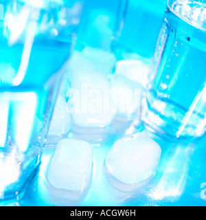 A cool crisp refreshing blue shot of ice cubes and glasses of water on a chrome background Stock Photo