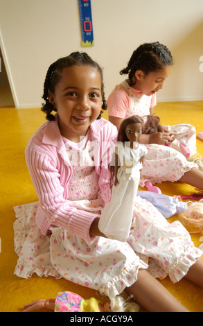 Two girls playing with dolls Stock Photo