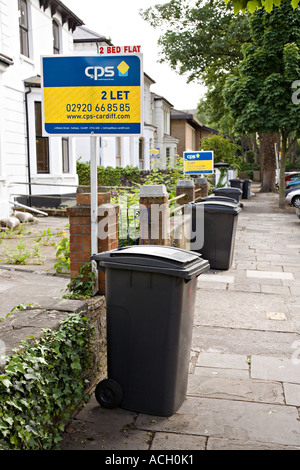 Wheely bins for refuse collection in residential street with flats to let signs in student area Cardiff Wales UK Stock Photo