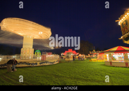 Fairground scene with fast spinning carousel Stock Photo - Alamy