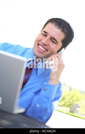 Young businessman using laptop and cell phone Stock Photo