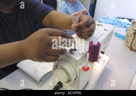 Student using sewing machine in sowing and making clothes class at north London college GB UK Stock Photo