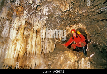Female caver with flowstone formations Mendip Somerset England UK Stock Photo