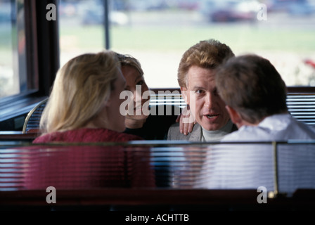 Two Caucasian couples talking over restaurant dinner Stock Photo