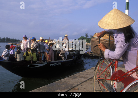 Asia Vietnam Hoi An Passengers unload goods from wooden ferry boat along Thu Bon River near Central Market Stock Photo