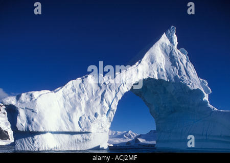 Antarctica Boothe Island Afternoon sun lights iceberg arch near Port Charcot southwest of Lemaire Channel Stock Photo