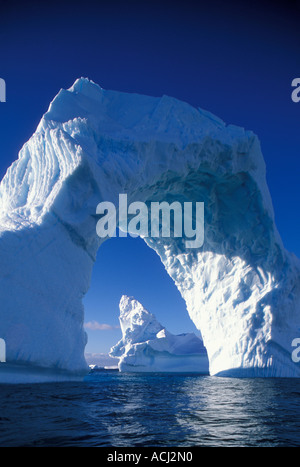 Antarctica Boothe Island Afternoon sun lights iceberg arch near Port Charcot southwest of Lemaire Channel Stock Photo