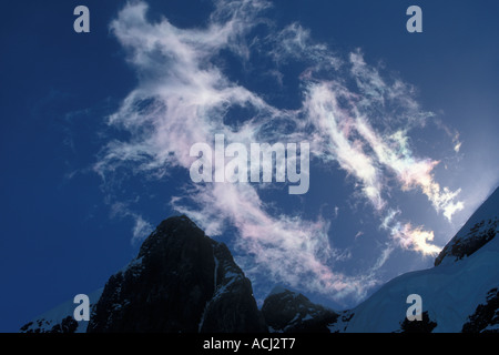 Antarctica Boothe Island Afternoon sun lights clouds swirling around mountain summits along Lemaire Channel Stock Photo